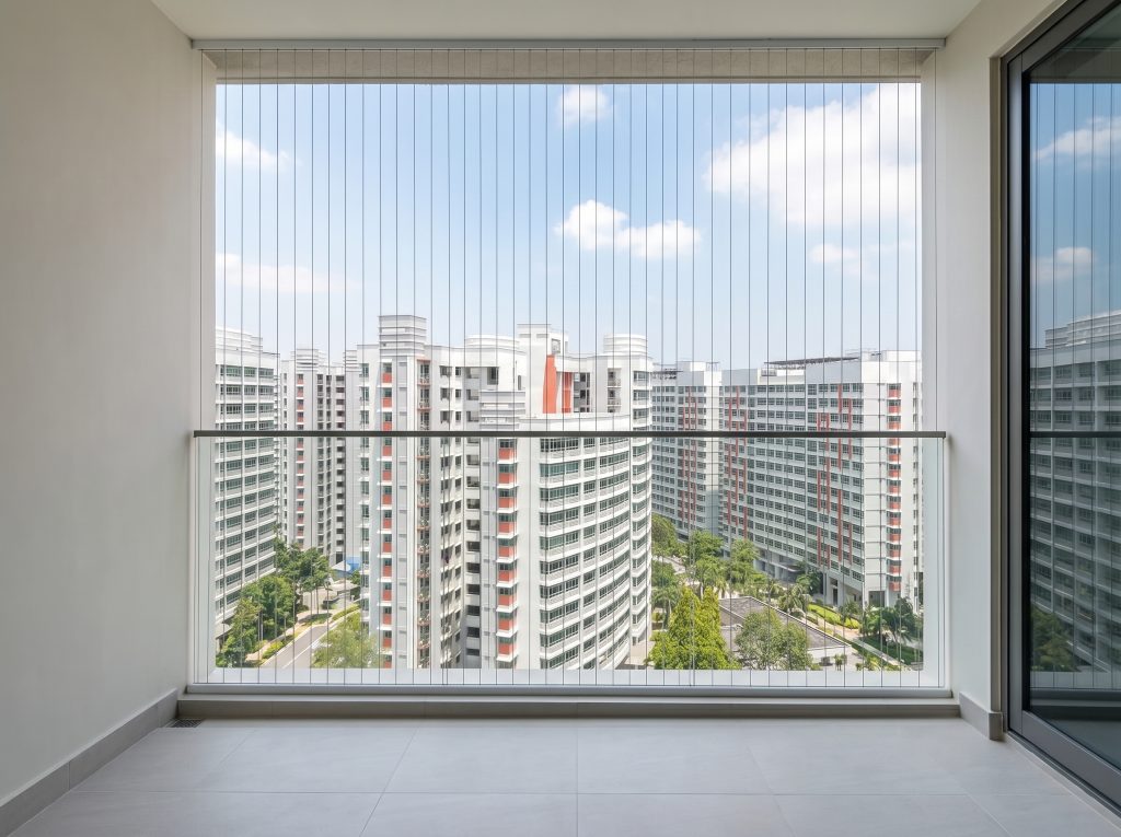 Fixed invisible window grille Singapore providing permanent fall protection for condo balconies.