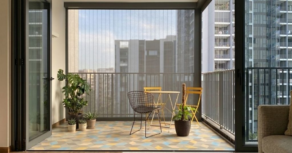 Home interior problems Singapore — transformed condo balcony with outdoor blinds, bistro table, and plants in natural light.
