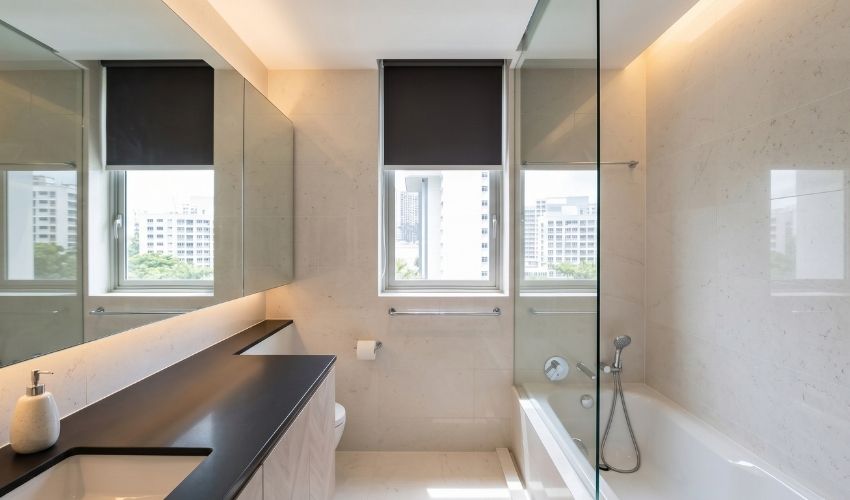 Frameless mirror and light neutral tones in a small Singapore HDB bathroom to create the illusion of more space